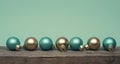 Golden and turquoise Christmas tree baubles on a wooden table Royalty Free Stock Photo