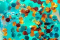 Golden and turquoise glitter in a liquid with bubbles. Beautiful abstraction shot in close-up. Colorful macro texture Royalty Free Stock Photo