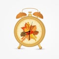 Golden vintage alarm clock with autumn leaves