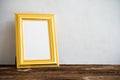 Golden vintage photo frame on old wooden table over white wall b Royalty Free Stock Photo