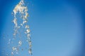 Golden water stream on blue background Royalty Free Stock Photo