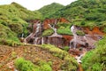 Golden Waterfall flowing over rust-colored rocks