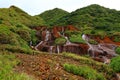 Golden Waterfall flowing over rust-colored rocks Royalty Free Stock Photo