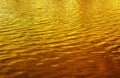Golden wavy background texture of golden water waves