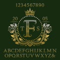 Golden wavy patterned letters and numbers with initial monogram in coat of arms form. Elegant font and elements kit for logo Royalty Free Stock Photo