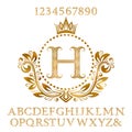 Golden wavy patterned letters and numbers with initial monogram in coat of arms form. Shining font and elements kit for logo Royalty Free Stock Photo