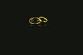 Golden wedding and love rings isolated on black background Royalty Free Stock Photo