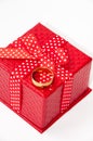 Golden wedding ring and red gift box with red bow Royalty Free Stock Photo