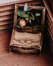 Golden wedding rings in the beautiful rustic box with flowers inside and on the wooden background Royalty Free Stock Photo