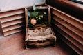 Golden wedding rings in the beautiful rustic box with flowers inside and on the wooden background Royalty Free Stock Photo