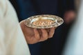 Golden wedding rings on a golden plate in the hands of a priest in the church