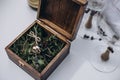 Golden wedding rings lie on the ropes in a wooden box with a mirror, which stands on the grass. Royalty Free Stock Photo