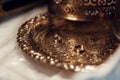 Golden wedding rings on metal plate in church with holy water. w