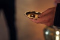 golden wedding rings on plate in priest hand at traditional ceremony in church
