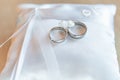 Golden wedding rings on white pillow ready for ceremony. The newlyweds will exchange their rings and say their promise Royalty Free Stock Photo