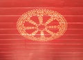 Golden wheel of life painting on the red wooden ceiling