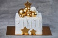 Golden white Christmas cake with chocolates golden and bronze balls. Isolated on grey.