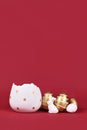 Golden and white easter eggs painted with stripes, bunny and egg cup at bottom of dark red background Royalty Free Stock Photo