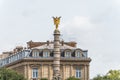 A golden winged statue on the top of a column in the downtown of Paris, France
