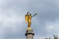 A golden winged statue on the top of a column in the downtown of Paris, France