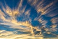 Golden wispy clouds, blue sky in background.