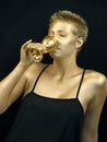 Golden woman drinking from a golden goblet