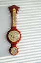 Golden wooden vintage barometer hangs on white wall in sunlight Royalty Free Stock Photo