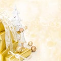 Golden wrapped christmas presents with an angel on wooden background.