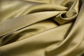 Golden yellow abstract background. Beautiful folds on shiny fabric. Silk satin texture background. Elegant gold background. Royalty Free Stock Photo