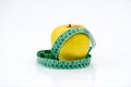 Golden Yellow apple and a green measuring tape on white background Royalty Free Stock Photo