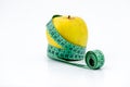 Golden Yellow apple and a green measuring tape on white background Royalty Free Stock Photo