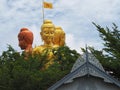 Golden yellow and copper Buddha, silver gray and silver, turquoise blue, white gray clouds, green leaves.