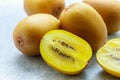 Golden yellow organic kiwi. Whole and cut ripe juicy fruits on grey background. kiwifruit Royalty Free Stock Photo