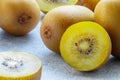 Golden yellow organic kiwi. Whole and cut ripe juicy fruits on grey background. kiwifruit Royalty Free Stock Photo