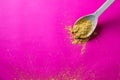 Golden yellow seasoning powder in wooden spoon for gourmet cuisine