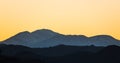 Golden yellow sky at sunset over snow-capped mountains and ridges above Joshua Tree National Park Royalty Free Stock Photo