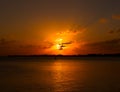 Golden yellow sunset over the sea ocean water with clouds and sun in the sky and reflection in the water with fisherman