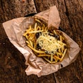 Golden yummy deep French fries on kraft baking sheet paper and serving tray to eat, lifestyle.