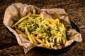 Golden yummy deep French fries on kraft baking sheet paper and serving tray to eat, lifestyle.