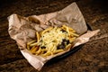 Golden yummy deep French fries on kraft baking sheet paper and serving tray to eat, lifestyle.