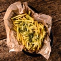 Golden yummy deep French fries on kraft baking sheet paper and serving tray to eat, lifestyle.