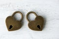 Two golden heart padlocks on wooden backrgound Royalty Free Stock Photo