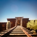 Goldfield Gold Mine`s old entrance to a gold mine shaft with rails leading inside, surrounded by cactuses Royalty Free Stock Photo