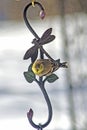 Goldfitch perches on a metal flower hanger. Royalty Free Stock Photo