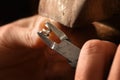 goldsmith hands working on a silver wire spiral with pliers small chain rings, macro shot with copy space