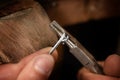 goldsmith hands wrap silver wire with pliers in a spiral for small chain rings, macro shot with copy space