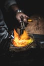 Goldsmiths melting metal to produce rings.