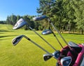 Golf bag with clubs on green field closeup