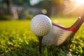 Golf ball and Blurred golf club close up in grass field with sunset Royalty Free Stock Photo