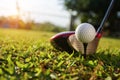 Golf ball and Blurred golf club close up in grass field with sunset Royalty Free Stock Photo